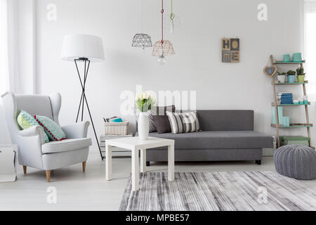 Inquadratura di un moderno soggiorno interno con una classica poltrona grigio Foto Stock