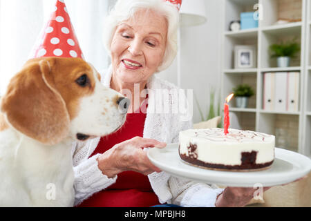 Senior donna Holding torta di compleanno Foto Stock