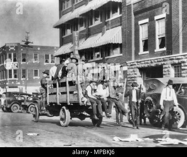 Carrello su strada vicino a Litan Hotel portante e i soldati americani Africani durante il Tulsa, Oklahoma race riot nel 1921 Foto Stock