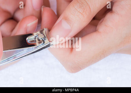 Primo piano di una donna il taglio di unghie, health care concetto. Foto Stock