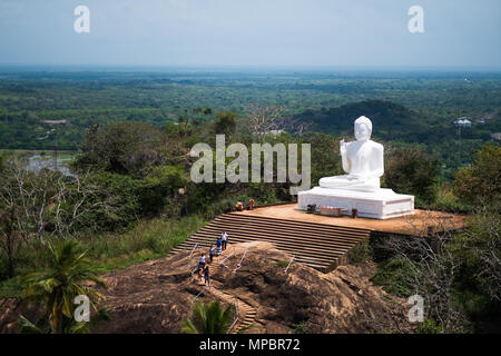 Mihintale, Sri Lanka - 07 Maggio 2018: bianco grande statua del Buddha contro il cielo blu in Mihintale Foto Stock