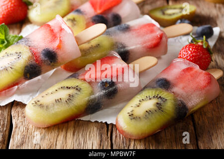 Estate dessert: ghiaccio di frutta con fragole, kiwi e mirtilli vicino sul tavolo orizzontale. Foto Stock