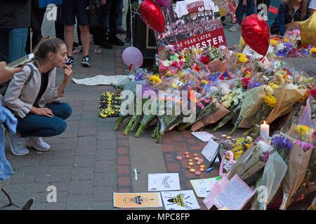 Manchester, Regno Unito. 22 Maggio, 2018. Giovane donna guardando il omaggi floreali a sinistra in St. Ann's Square nel centro di Manchester, a ricordare il 22 vittime dei bombardamenti contro il Manchester Arena, dopo il concerto dato dalla cantante americana Ariana Grande. Credito: Rob Carter/Alamy Live News Foto Stock