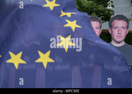 Bruxelles, Belgio. 22 Maggio, 2018. Un manifestante detiene una bandiera UE accanto a ritagli di cartone raffigurante il boss di Facebook Mark Zuckerberg nel corso di una manifestazione a Bruxelles in anticipo la sua apparizione davanti al Parlamento europeo. Credito: Riccardo Pareggiani/ZUMA filo/Alamy Live News Foto Stock