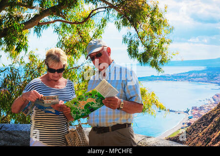 Taormina, Italia - 25 Settembre 2017: coppia Senior guardando la mappa turistica di Taormina, Sicilia, Italia Foto Stock