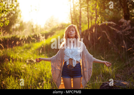 Felice giovane donna godendo di una splendida serata. Tempo caldo, estate, campo Foto Stock