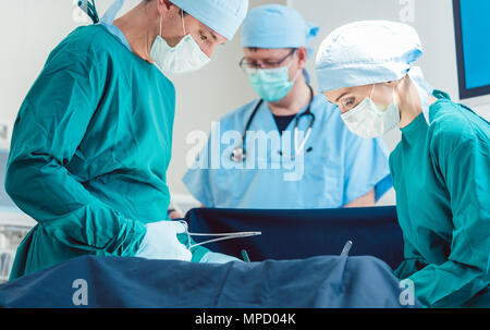 Medico Chirurgico in piena concentrazione sul funzionamento Foto Stock