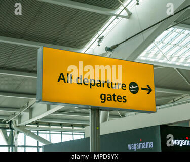 Cancelli di partenza direzionale segno giallo, terminale 5, l'aeroporto di Heathrow di Londra, Inghilterra, Regno Unito Foto Stock