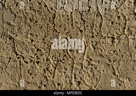 Background e texture - marrone parete di argilla con urti e crepe Foto Stock