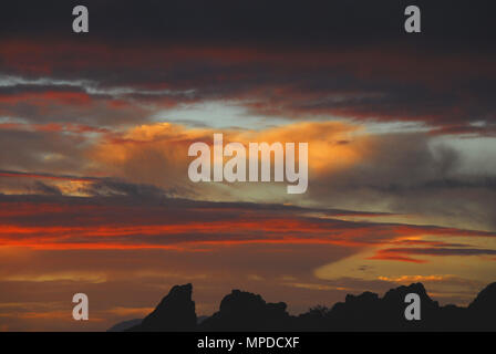 Il punto costiero che è Rooi Els, il Sud Africa ha enormi massi ruvida che creano un bel contrasto contro questo magnifico tramonto. Foto Stock