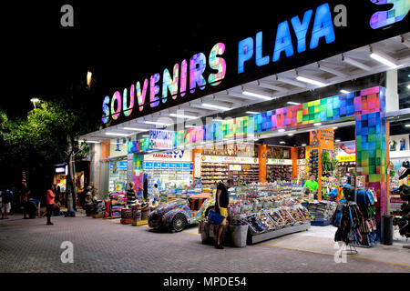 Notte lungo la Quinta Avenida, Playa del Carmen Quintana Roo, Messico. Colorato 'souvenir' negozi vendono di tutto la prescrizione di farmaci e tee shirt per Foto Stock