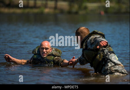 Stati Uniti Esercito nazionale del personale di guardia Sgt. Erich Friedlein tira Capt. Robert Killian a Riva durante la migliore concorrenza Ranger 2017 a Fort Benning, Ga., Aprile 9, 2017. La trentaquattresima edizione annuale di David E. Grange Junior Ranger migliore concorrenza 2017 è un evento di tre giorni consistente di sfide per testare concorrente del fisico, mentale e capacità tecniche. Foto Stock