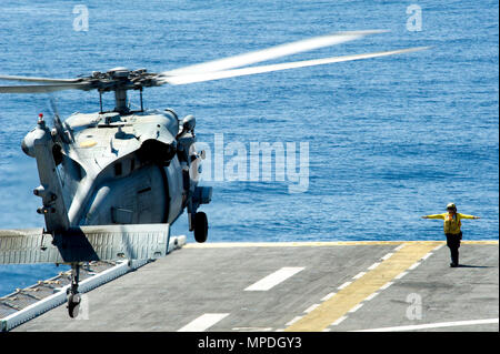 Oceano Pacifico (10 aprile 2017) dell'aviazione di Boatswain Mate (movimentazione) terza classe Sarah Heaton, nativo di Fredonia, Ariz., guida una SH-60 Seahawk come si atterra sul ponte di volo dell'assalto anfibio nave USS America (LHA 6). L'America è attualmente in corso con più di mille velisti e 1.600 imbarcati Marines conduttore squadrone anfibio/Marine Expeditionary Unit le operazioni di integrazione in preparazione per la nave da nubile di distribuzione entro la fine di quest'anno. Foto Stock