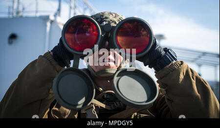 Master-at-Arms 2a classe Emilio Donatlan, assegnato a Costiera gruppo fluviale 1, utilizza il binocolo a scansionare l'orizzonte durante una piccola barca con lo scenario di addestramento al largo della costa di Pohang, Repubblica di Corea, durante il funzionamento del pacifico esercizio di raggiungere 2017 (OPRex17) Il 10 aprile 2017. OPRex17 è un accordo bilaterale per l'evento di formazione progettati al fine di garantire la preparazione e sostenere la Rok-STATI UNITI alliance esercitando una zona al centro di distribuzione aria un terminale punto di alimentazione, combined joint logistics over-the-shore, l'uso della ferrovia, vie di navigazione interna e costiera di operazioni di sollevamento per convalidare il funzionamento concetto reach. Foto Stock