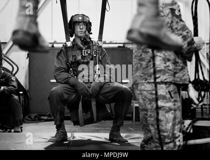 Un membro del XXIII Bomb Squadron si blocca in una simulazione di paracadute sui cavi in corrispondenza di Minot Air Force Base, N.D., 22 febbraio, 2017. Uscita e paracadute di emergenza di formazione personale insegna come tranquillamente uscire dall'aereo e tornare a terra dopo un'emergenza. (U.S. Air Force foto/Senior Airman J.T. Armstrong) Foto Stock