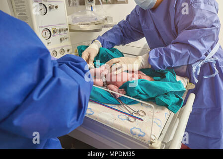 Medico controllo temperatura del neonato in ospedale sfondo Foto Stock
