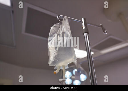 La sacca per infusione con liquido di sgocciolii vista ravvicinata su sfondo ospedale Foto Stock