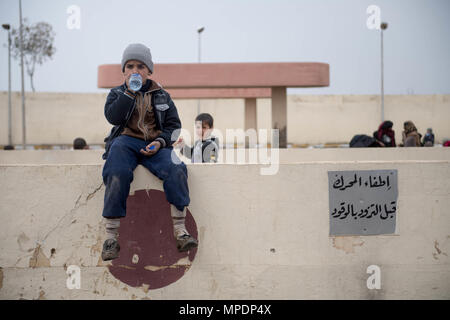 Un internamente sfollati bambino attende in corrispondenza di una stazione di lavorazione in preparazione per essere trasportati in campi per rifugiati nei pressi di Mosul, Iraq, Marzo 03, 2017. (U.S. Foto dell'esercito da Staff Sgt. Alex Manne) Foto Stock