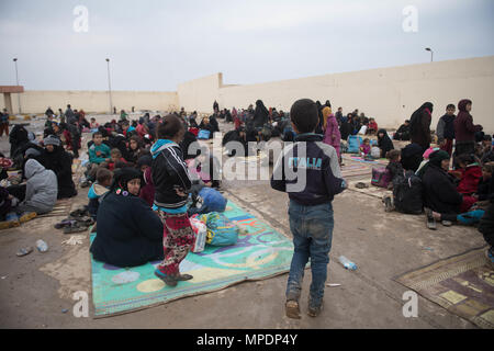 Le donne e i bambini in attesa in una stazione di lavorazione per gli sfollati interni prima di essere trasportati in campi per rifugiati nei pressi di Mosul, Iraq, Marzo 03, 2017. (U.S. Foto dell'esercito da Staff Sgt. Alex Manne) Foto Stock