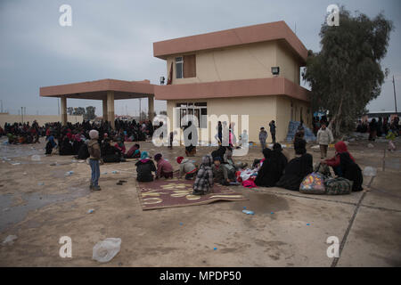 Le donne e i bambini in attesa in una stazione di lavorazione per gli sfollati interni prima di essere trasportati in campi per rifugiati nei pressi di Mosul, Iraq, Marzo 03, 2017. (U.S. Foto dell'esercito da Staff Sgt. Alex Manne) Foto Stock