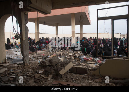 Le donne e i bambini in attesa in una stazione di lavorazione per gli sfollati interni prima di salire a bordo degli autobus in campi per rifugiati nei pressi di Mosul, Iraq, Marzo 03, 2017. (U.S. Foto dell'esercito da Staff Sgt. Alex Manne) Foto Stock