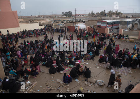 Le donne e i bambini in attesa in una stazione di lavorazione per gli sfollati interni prima di salire a bordo degli autobus in campi per rifugiati nei pressi di Mosul, Iraq, Marzo 03, 2017. (U.S. Foto dell'esercito da Staff Sgt. Alex Manne) Foto Stock