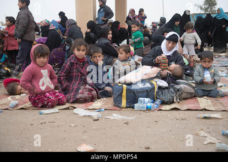 Le donne e i bambini in attesa in una stazione di lavorazione per gli sfollati interni prima di essere trasportati in campi per rifugiati nei pressi di Mosul, Iraq, Marzo 03, 2017. (U.S. Foto dell'esercito da Staff Sgt. Alex Manne) Foto Stock