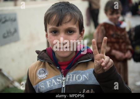 Un bambino attende in corrispondenza di una stazione di lavorazione per gli sfollati interni prima di essere trasportati in campi per rifugiati nei pressi di Mosul, Iraq, Marzo 03, 2017. (U.S. Foto dell'esercito da Staff Sgt. Alex Manne) Foto Stock