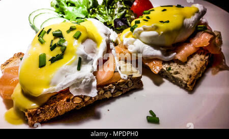 Uova Benedict con salmone affumicato su fette di pane abbrustolito. (Colazione concetto) Foto Stock