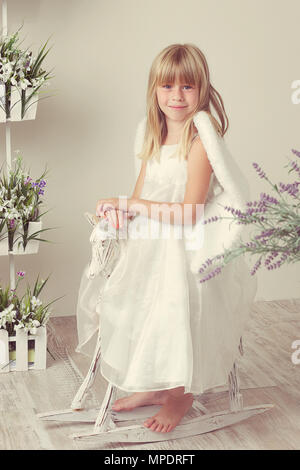 Una bambina in un Angelo vestito Foto Stock