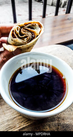 Caffè con la crêpe al cioccolato (street food). street dessert Foto Stock