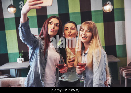Foto presentazione felice gruppo di amici con un bicchiere di vino rosso tenendo selfie Foto Stock