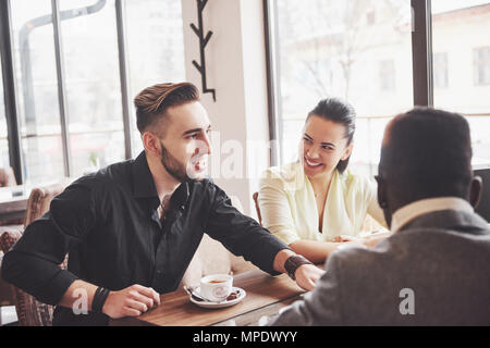 La diversità di avvio al lavoro di squadra Riunione di brainstorming Concept. Il team di Business collaboratori condivisione economia mondiale relazione documento portatile.persone che lavorano la pianificazione avvia.Gruppo Giovani Hipsters discutendo Cafe Foto Stock