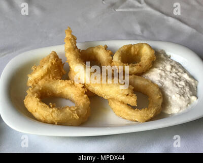 Fritti di calamari croccanti anelli di totano con salsa tartara al ristorante. Frutti di mare Foto Stock