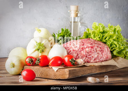 Mixe di macinato di carne di carne di manzo e di maiale sminuzzata impostato per la cottura barbecue spiedini di bistecche salsicce fritte sul fuoco verdure alimentare Pomodori ciliegia foglie di lattuga Foto Stock