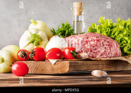 Mixe di macinato di carne di carne di manzo e di maiale sminuzzata impostato per la cottura barbecue spiedini di bistecche salsicce fritte sul fuoco verdure alimentare Pomodori ciliegia foglie di lattuga Foto Stock