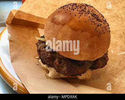 Burger di agnello con formaggio fuso contemplati nella Carta Craft servita al ristorante. Fast Food. Foto Stock