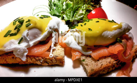 Uova Benedict con salmone affumicato su fette di pane abbrustolito. (Colazione concetto) Foto Stock