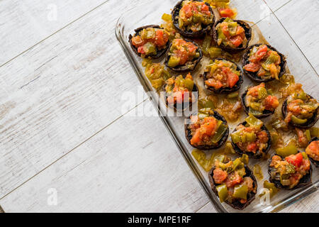 Funghi cotti farcite con pomodori e il peperone verde. Alimenti biologici. Foto Stock