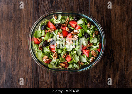 Purslane con insalata di noce, pomodori e olive su una superficie di legno. Alimenti biologici concetto. Foto Stock