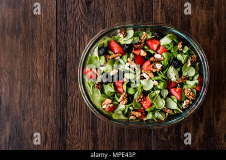 Purslane con insalata di noce, pomodori e olive su una superficie di legno. Alimenti biologici concetto. Foto Stock