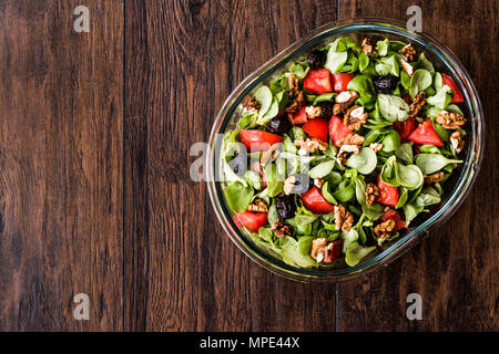 Purslane con insalata di noce, pomodori e olive su una superficie di legno. Alimenti biologici concetto. Foto Stock