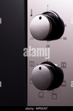 Termostato e manici su un moderno forno a microonde, close-up. Attrezzature per cucina Foto Stock