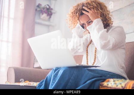 Donna disperata caucasian mentre il lavoro a casa con il computer portatile su stock exchange o qualcosa di simile per il lavoro in modalità remota. crazy su internet o problemi sul Foto Stock