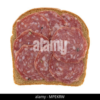 Vista dall'alto di una singola fetta di pane di grano coperto con la soppressata non indurito salame a secco isolato su uno sfondo bianco. Foto Stock