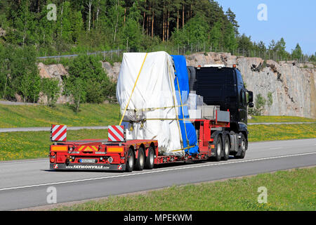 Nero Volvo FH semi rimorchio cale oggetto industriale come carico oversize lungo la superstrada in una giornata di sole, in vista posteriore Paimio, Finlandia - 18 maggio 2018. Foto Stock