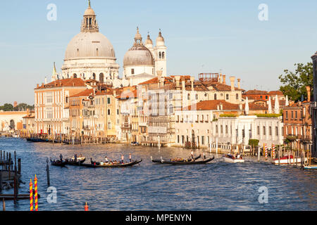 Grand Canal, Basilica di Santa Maria della Salute al tramonto, Dorsoduro, Venezia, Veneto, Italia con gondole e gondolieri con turisti Foto Stock