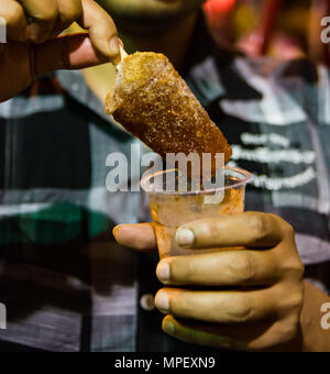 Kala khatta gola tenuto in mano del ghiaccio tritato immersa in sciroppo speziato. indian ristoro. Foto Stock