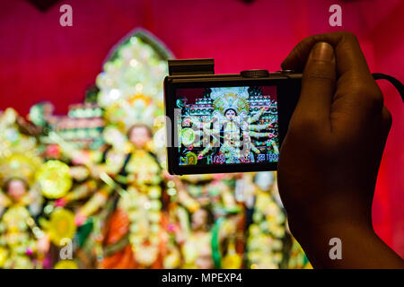 Macchina fotografica in mano prendendo foto di durga idolo in background leggera profondità di campo Foto Stock