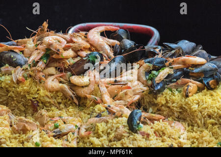 Una grande padella di paella essendo cotti sul mondo da asporto street food stallo a Borough Market nel centro di Londra. La cucina spagnola e nazionali di piatto di frutti di mare. Foto Stock